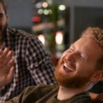 A Group of dads laughing at either a bar or bowling ally