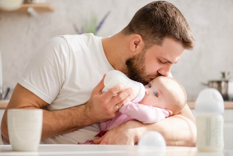 father feeding baby bottle