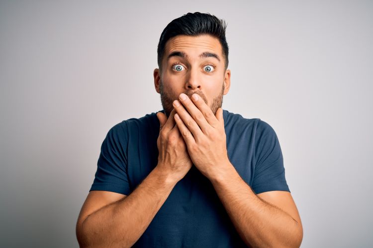 man covers mouth in shock at dirty things he said