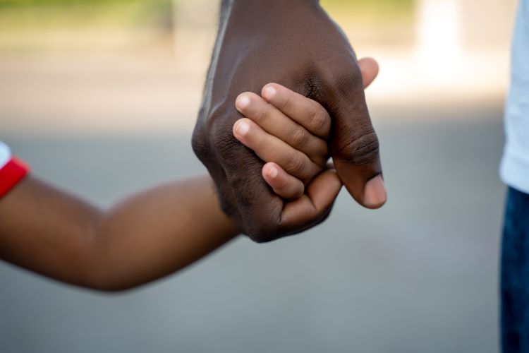 manny kidnapper black hand holding lighter skin child hand