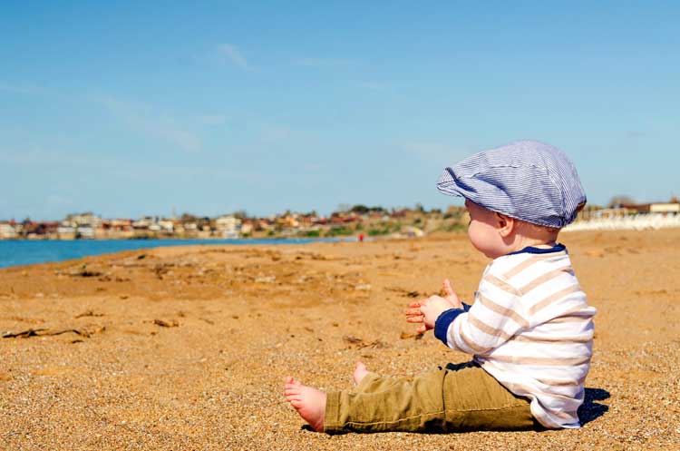 baby on beach clapping