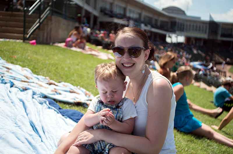 baseball mom holds child at baseball game
