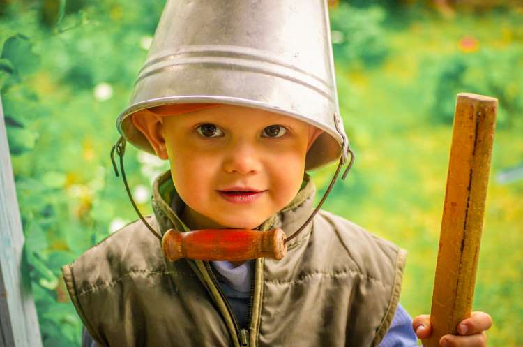 child with bucket on head