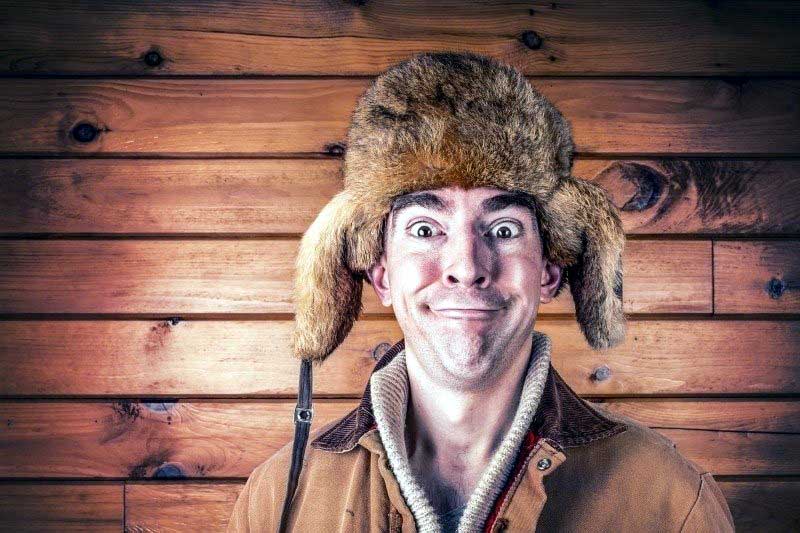man with goofy smile in fur hat