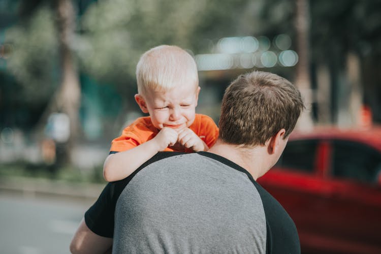 dad carries crying child