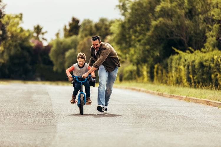 dad help son ride bike 2