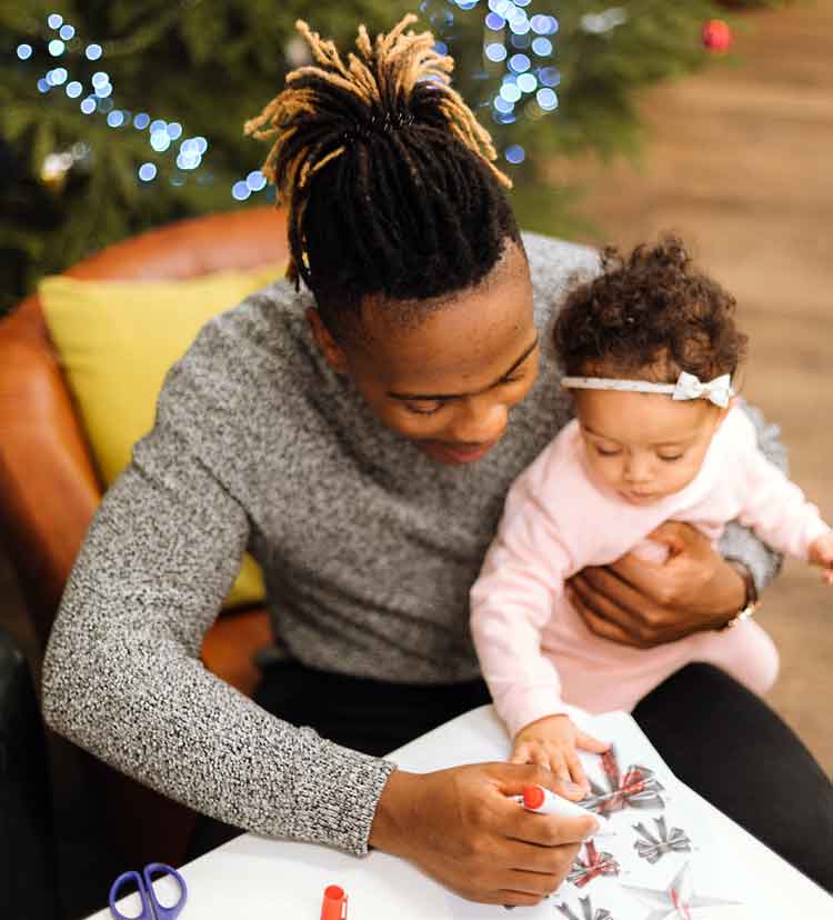 father holds baby while coloring