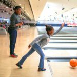 girl bowling with mom