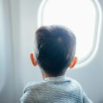boy airplane window family travel tips