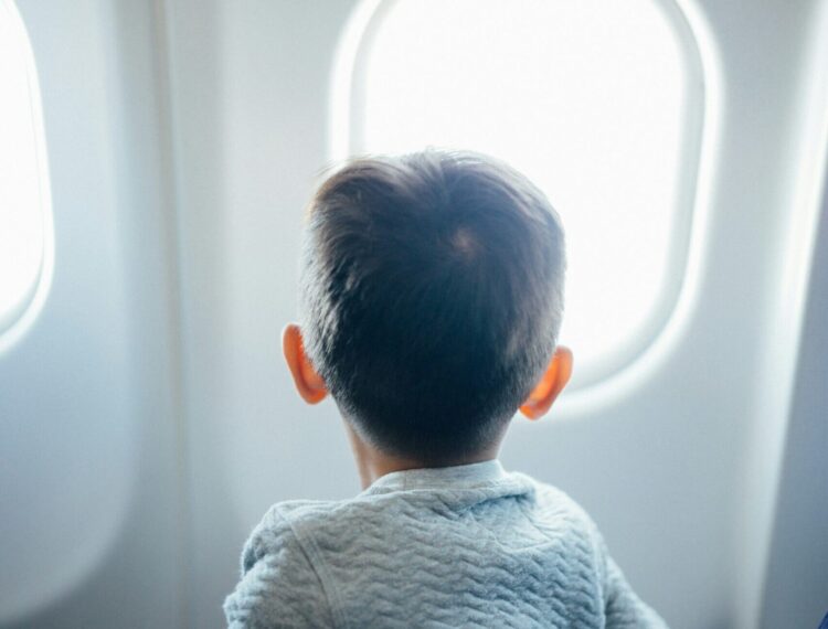 boy airplane window family travel tips