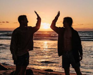 guys friends high five beach sunset