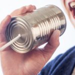 communication man talks into tin can