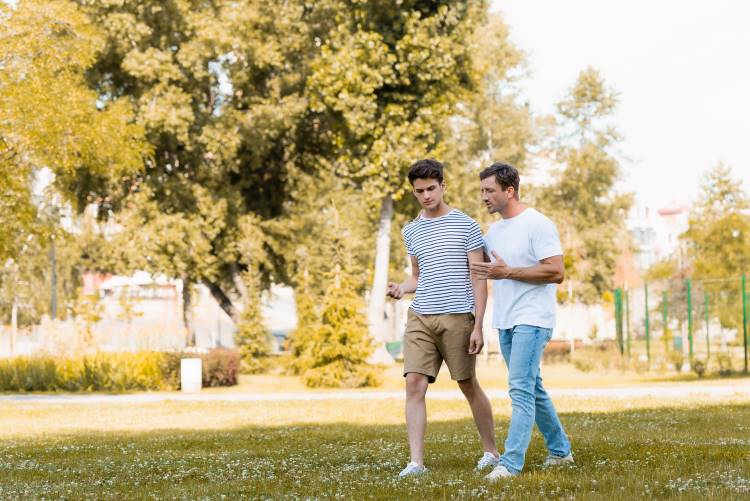 parent teen communication father son walk talk in park 1