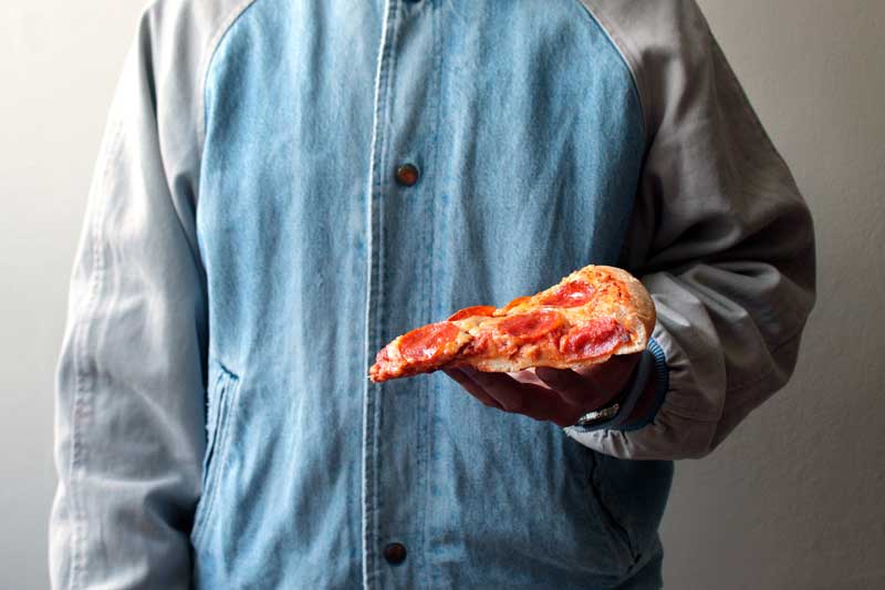 pizza slice held by a boy