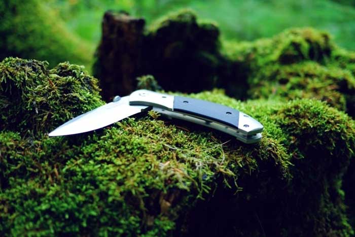 pocket knife on mossy rocks