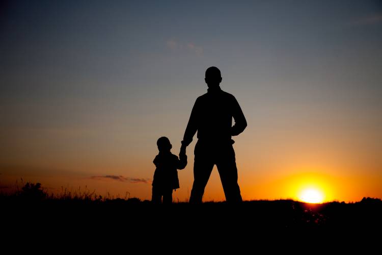 presence over presents silhouette of father and son holding hands at sunset