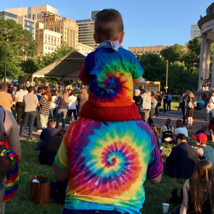 Adult and child in rainbow tie-dyes at Pride Parade.
