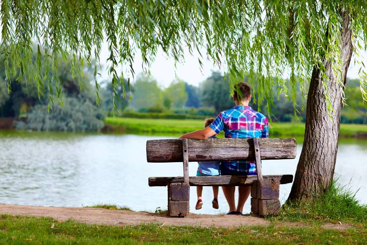 remembering dad and son sitting on bench by lake