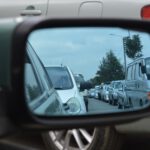 school pickup line traffic jam in car side view mirror