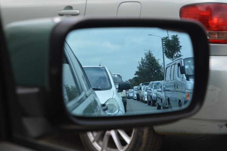 school pickup line traffic jam in car side view mirror