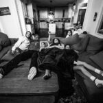 sit family watching tv couch