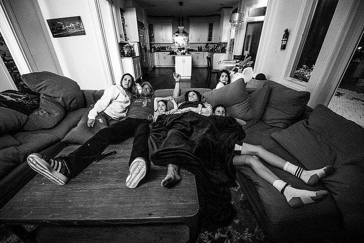 sit family watching tv couch