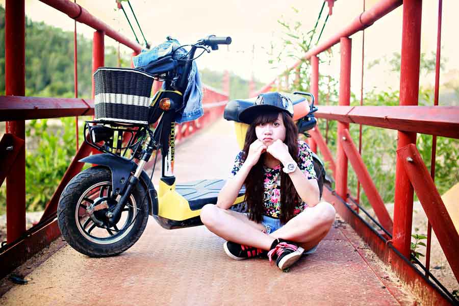 validate teen girls daughter sitting on bridge with bike