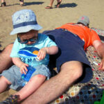 tired parent on beach