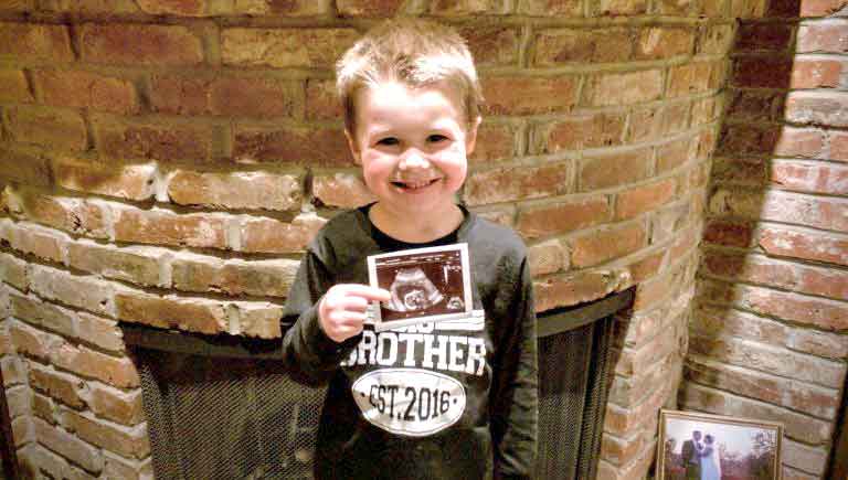 unborn son brother holds sonogram