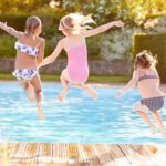 young girls in swimsuit jump into pool