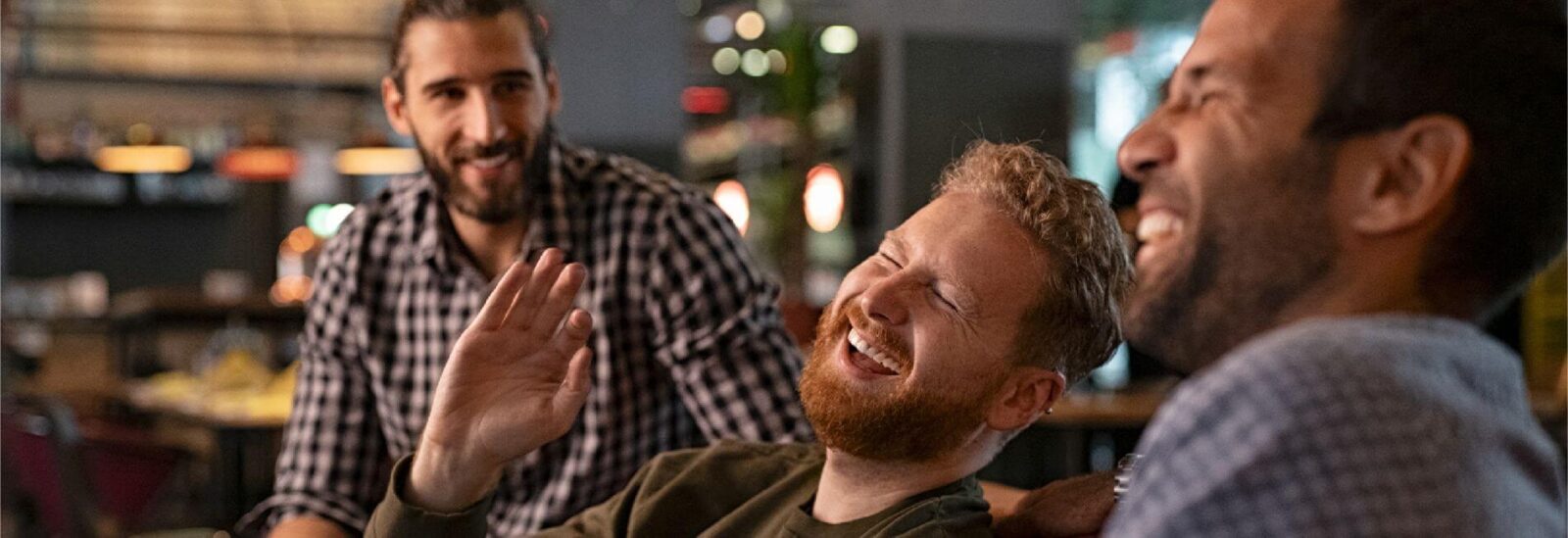 A Group of dads laughing at either a bar or bowling ally